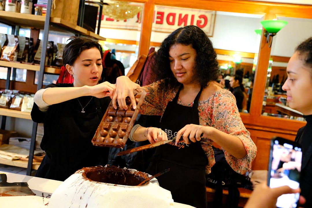 Two participants molding praline chocolates