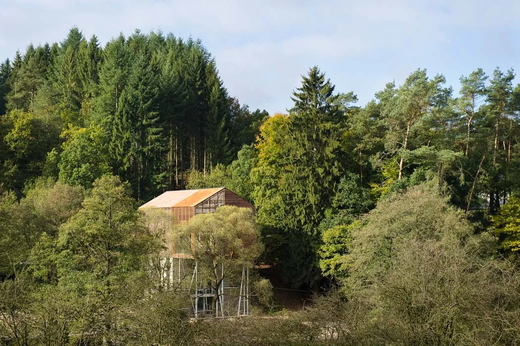 La Fabrique du Pré Maho — passive timber-on-stilts annex on the river bank