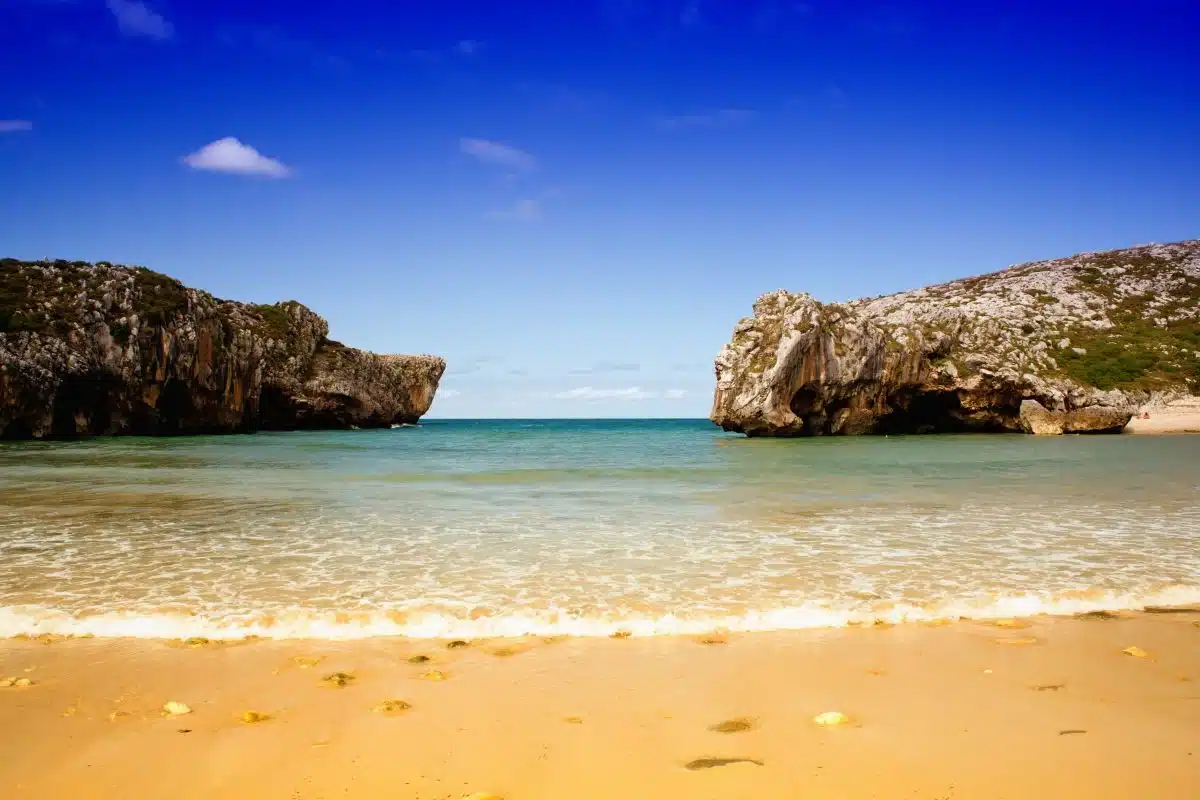 Cuevas del Mar beach with karst sea arches at the Cuevas river mouth