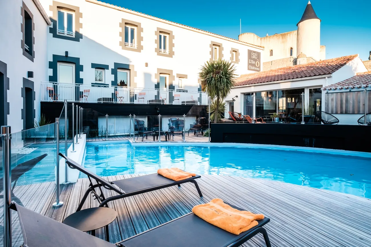 Hôtel L'Île Ô Château — heated pool with castle view