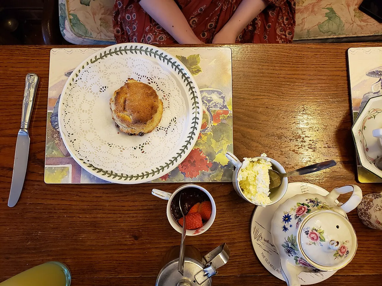 Colonial high tea — scones and a pot of tea on a garden lawn