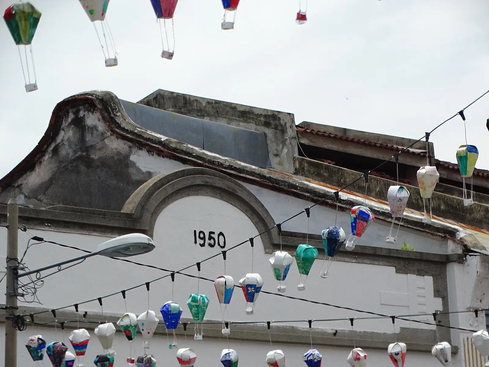 Painted paper lanterns strung over a 1950 heritage shophouse in George Town