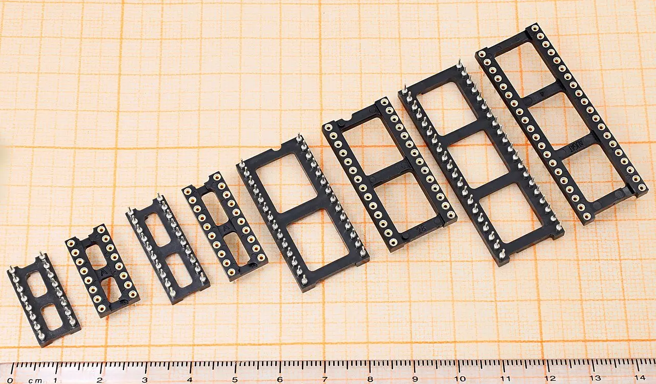 A row of empty DIP sockets in ascending pin counts, laid on graph paper