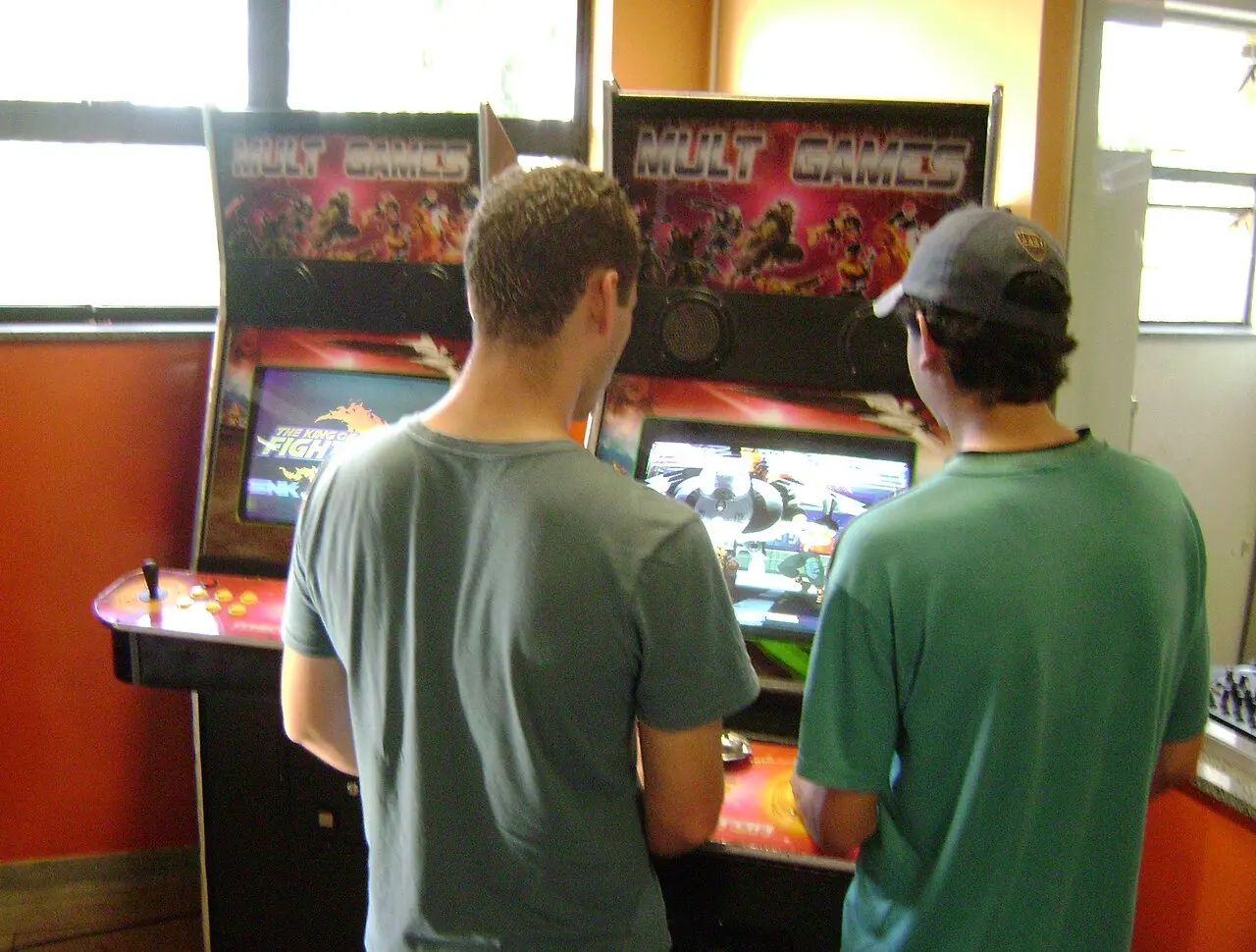 A row of lit arcade cabinets in a games arcade