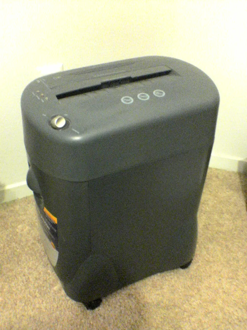 An office paper shredder with a wastebasket beneath it