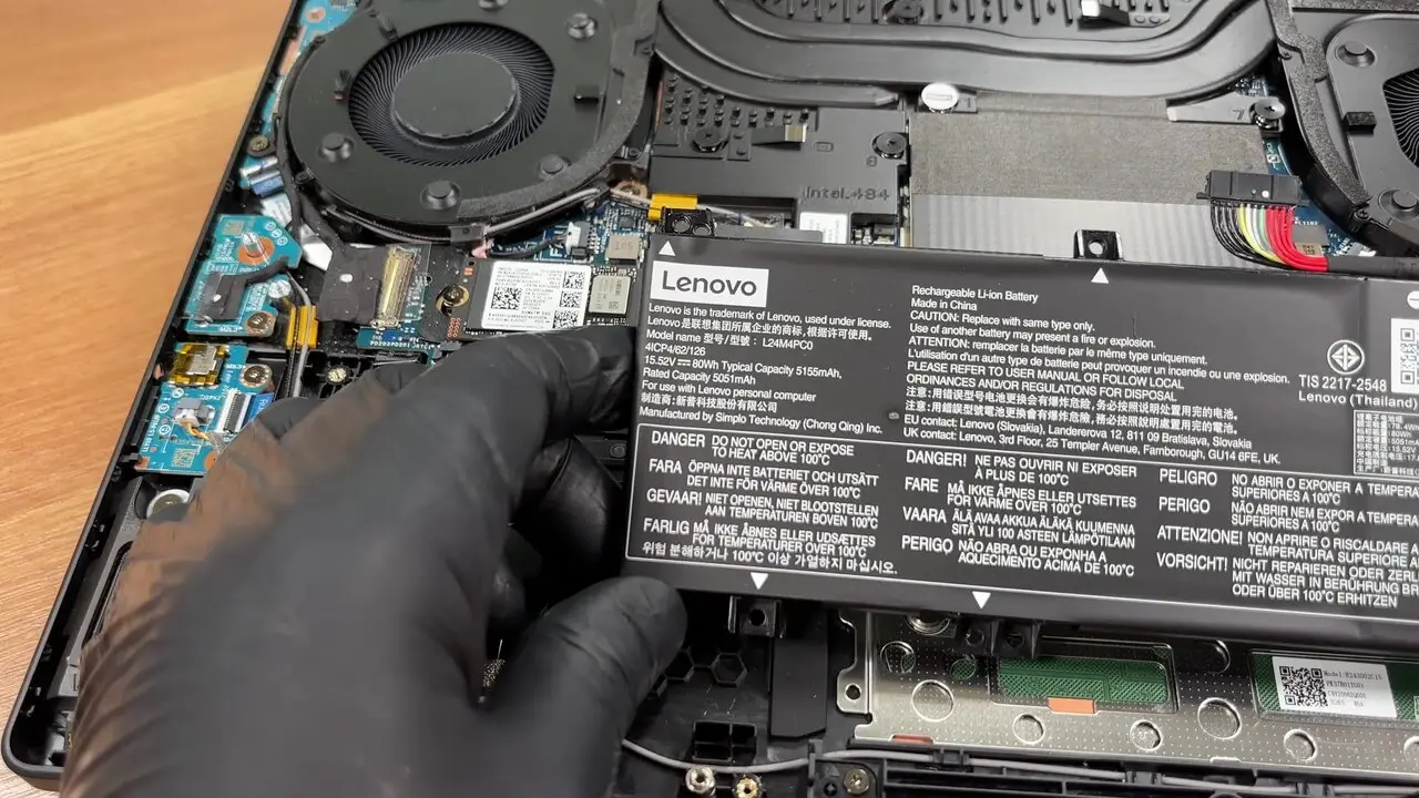Interior of a Lenovo Legion 5i laptop with the bottom cover removed, showing fans, battery and mainboard