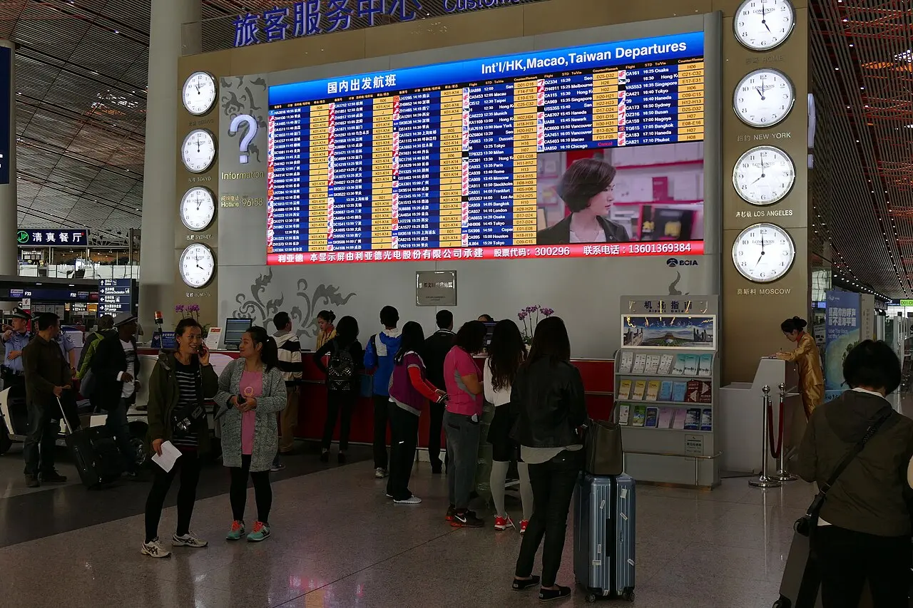 An airport departures board in a terminal hall