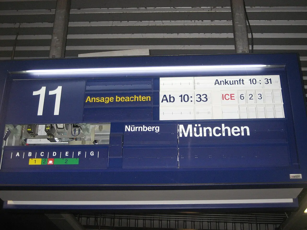 A split-flap departure board on a railway platform