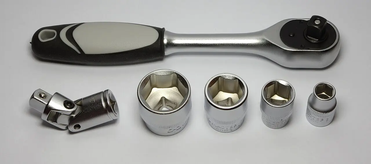 Socket wrench and a row of loose sockets laid out on a bench