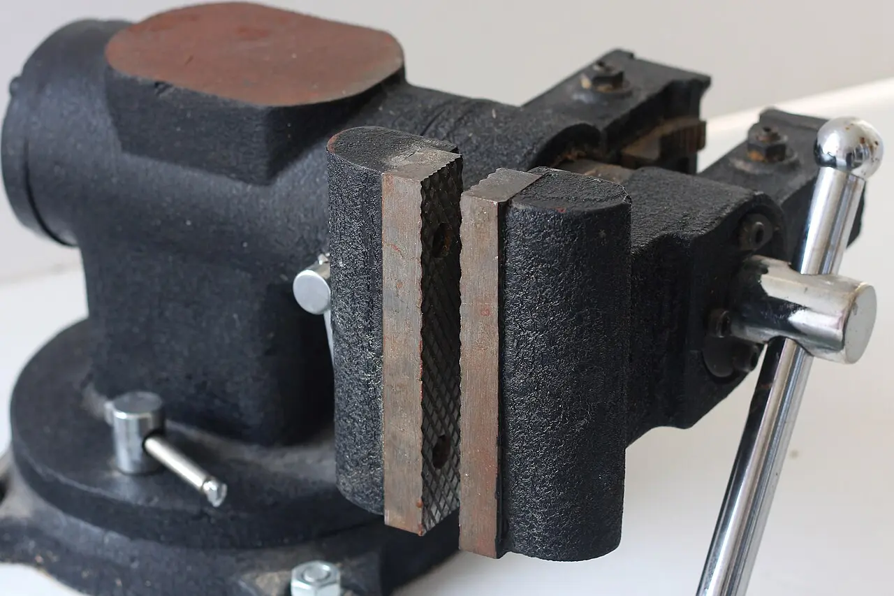 An engineer's bench vise clamped to a workbench