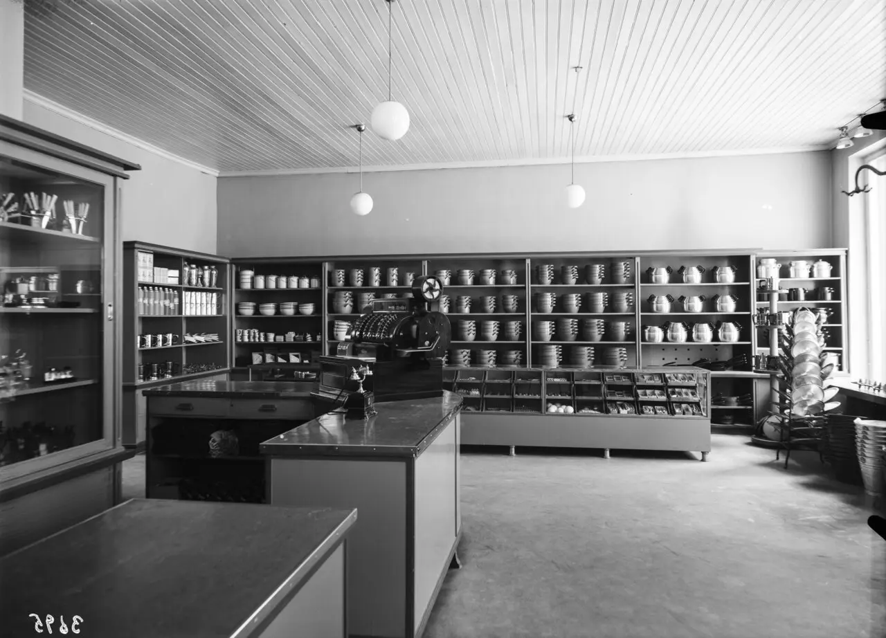 Interior of a cooperative hardware store, 1942, shelves and counters stacked with tools and parts