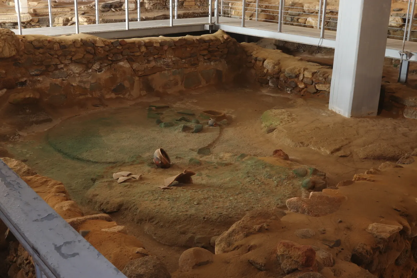 Excavated foundations and pottery under the walkway of the Mitropolis site museum
