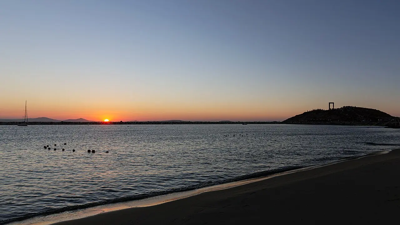 The Portara of Naxos silhouetted against the sunset over the Aegean