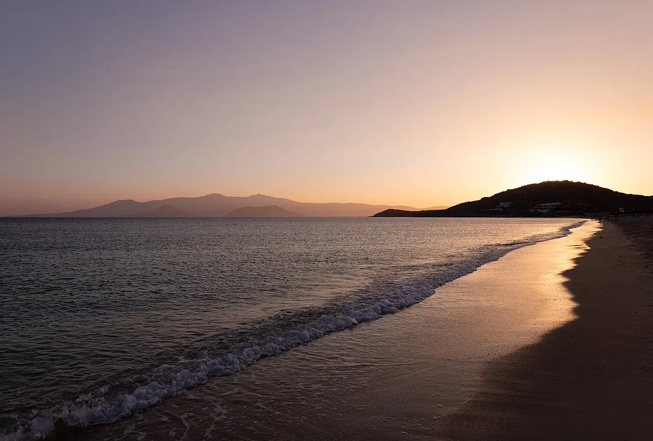 Agios Prokopios beach on Naxos at low sun, sheltered golden sand behind the Stelida headland